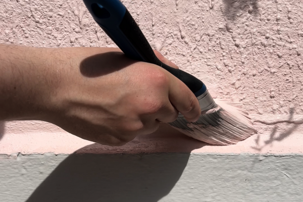 Masonry paint being applied to a masonry wall